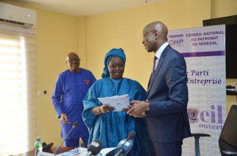 La vice présidente du CNP remettant un exemplaire du rapport au Ministre Samba SY